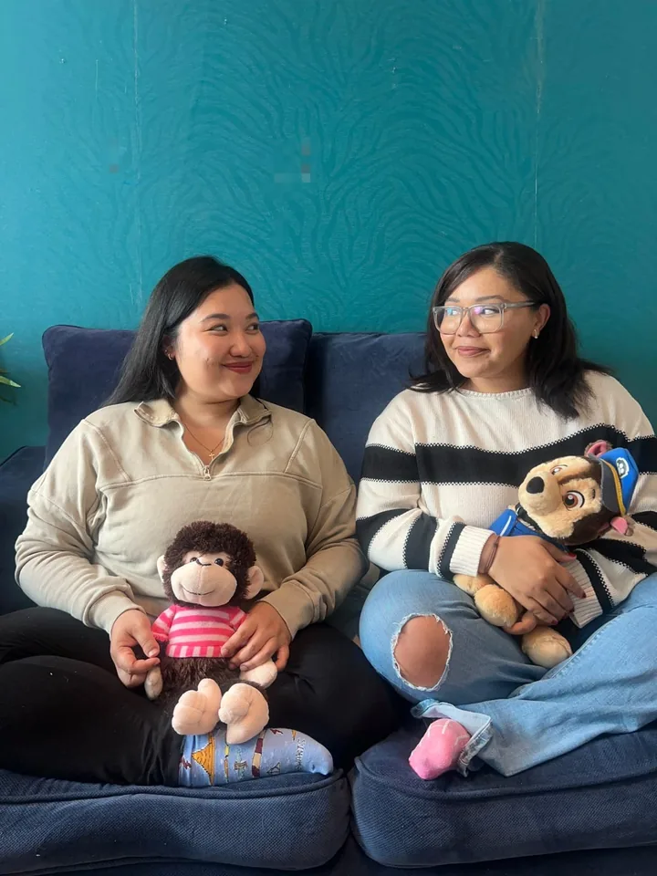 Beth sitting on the floor of a therapy room holding a soft toy